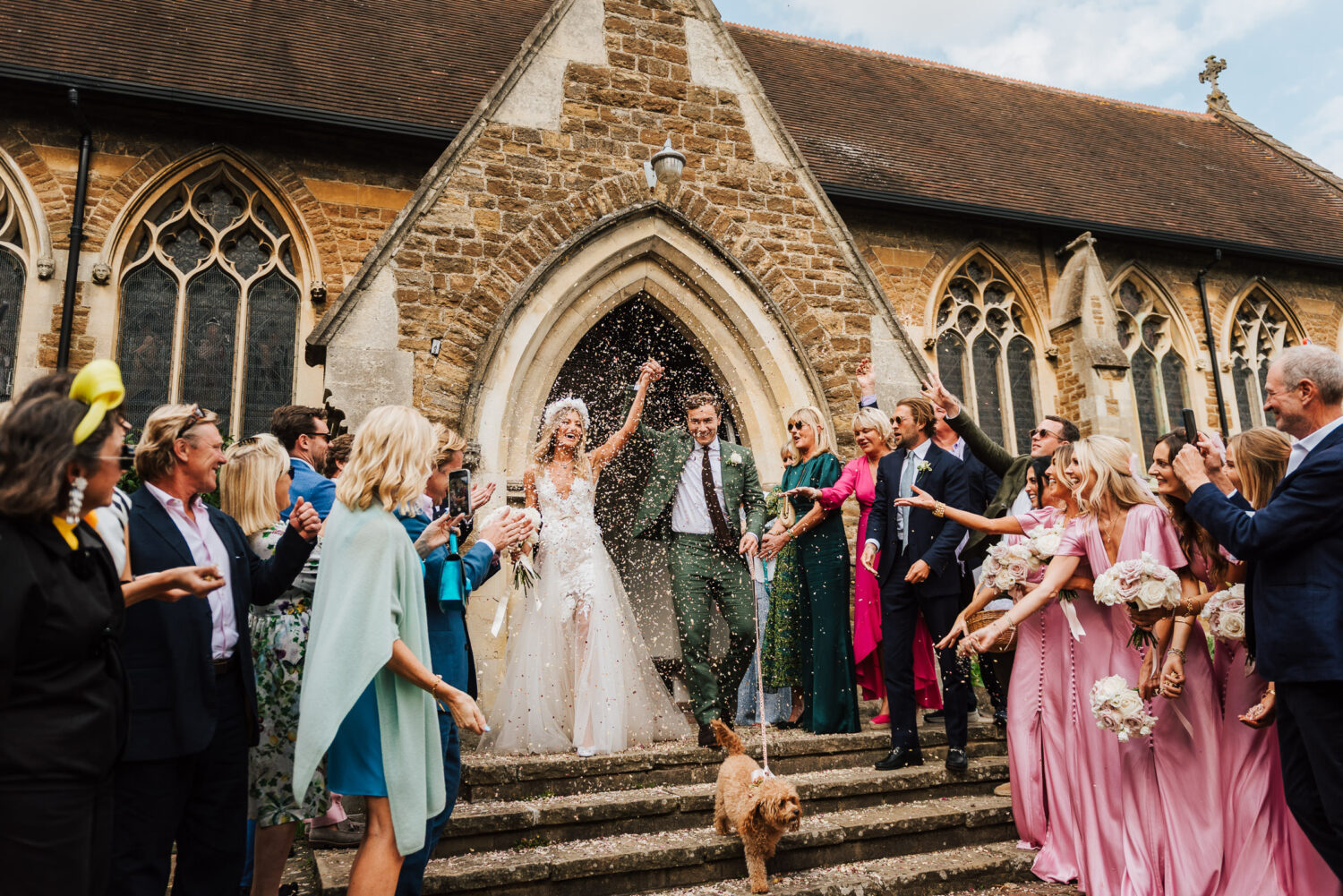 A newley married couple walking out of church under confetti