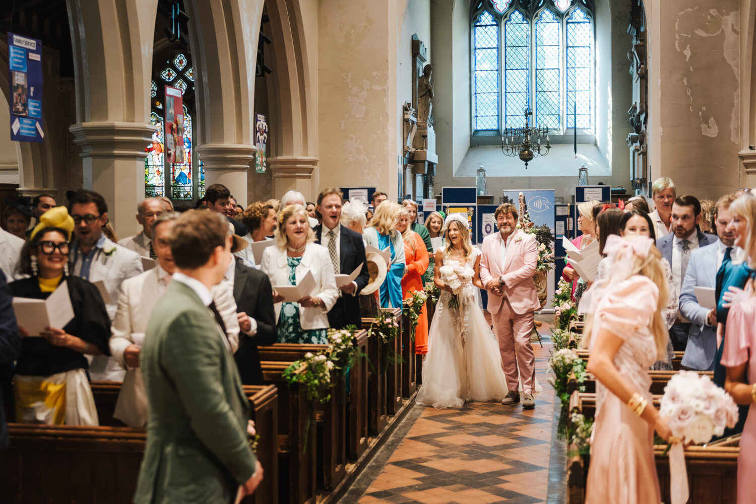 A bride and father walking down the church aisle