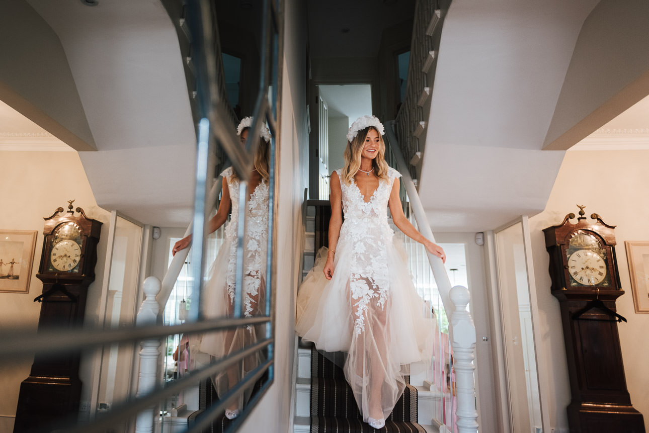 A beautiful London bride walking down the stairs in her wedding dress
