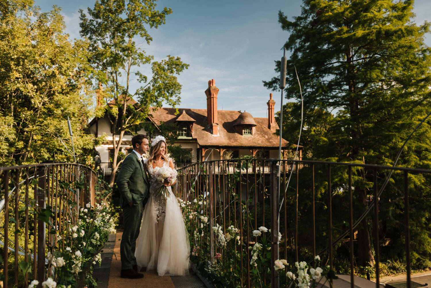 A Super Stylish Couple In A Wedding Dress and Suit Standing on the Bridge to D'oyly Carte Island