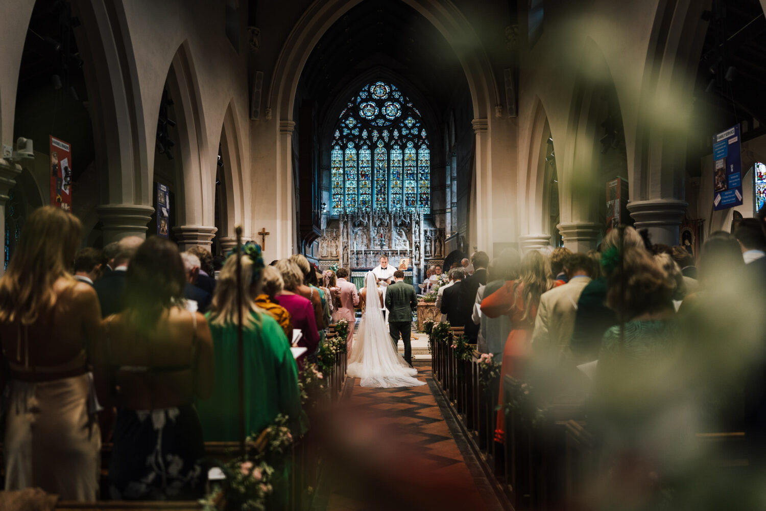 A view of a couple getting married from the back of the church