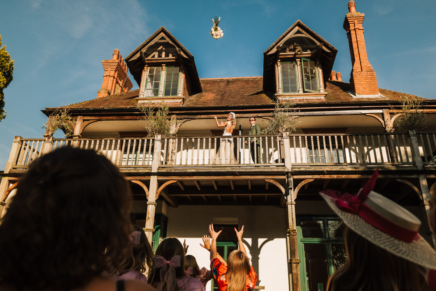 Lily and Jack throwing the wedding bouquet off the balcony of D'oyly Carte Island for their wedding party