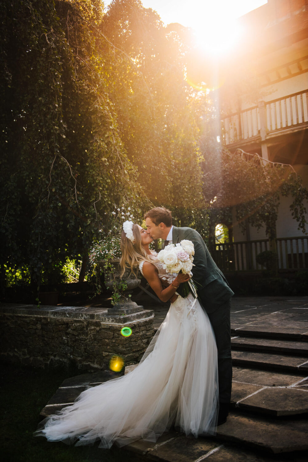 A bride being dipped and kissed in bright sunshine