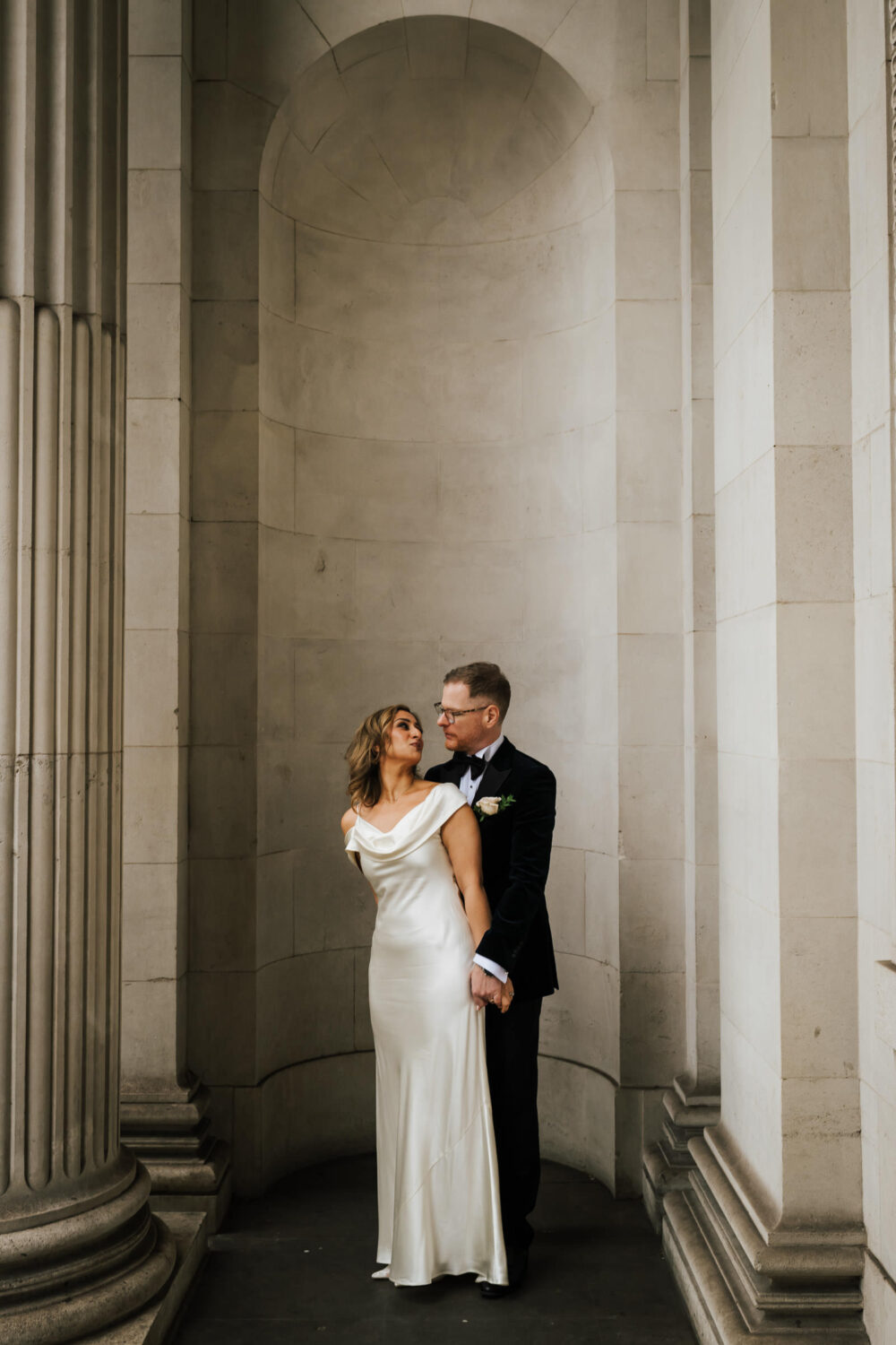 A newly married couple kissing outside of Old Marylebone Town Hall in London
