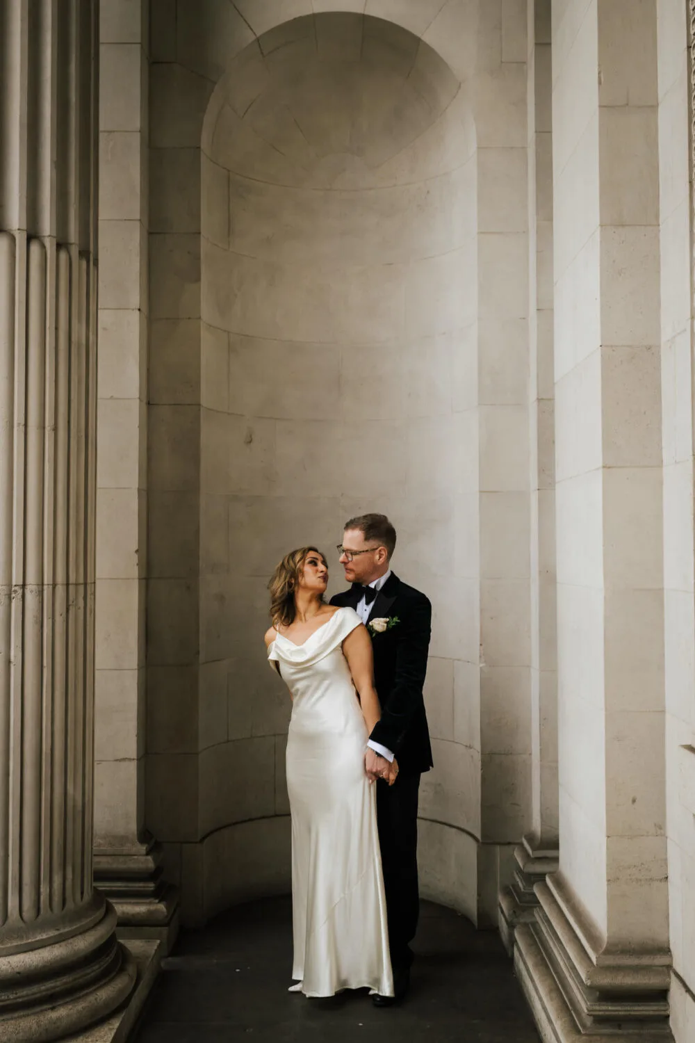 A newly married couple kissing outside of Old Marylebone Town Hall in London