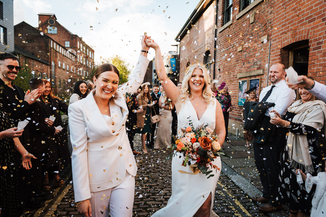 Wedding guests throwing confetti over a same sex couple outside The Chimney House in Sheffield