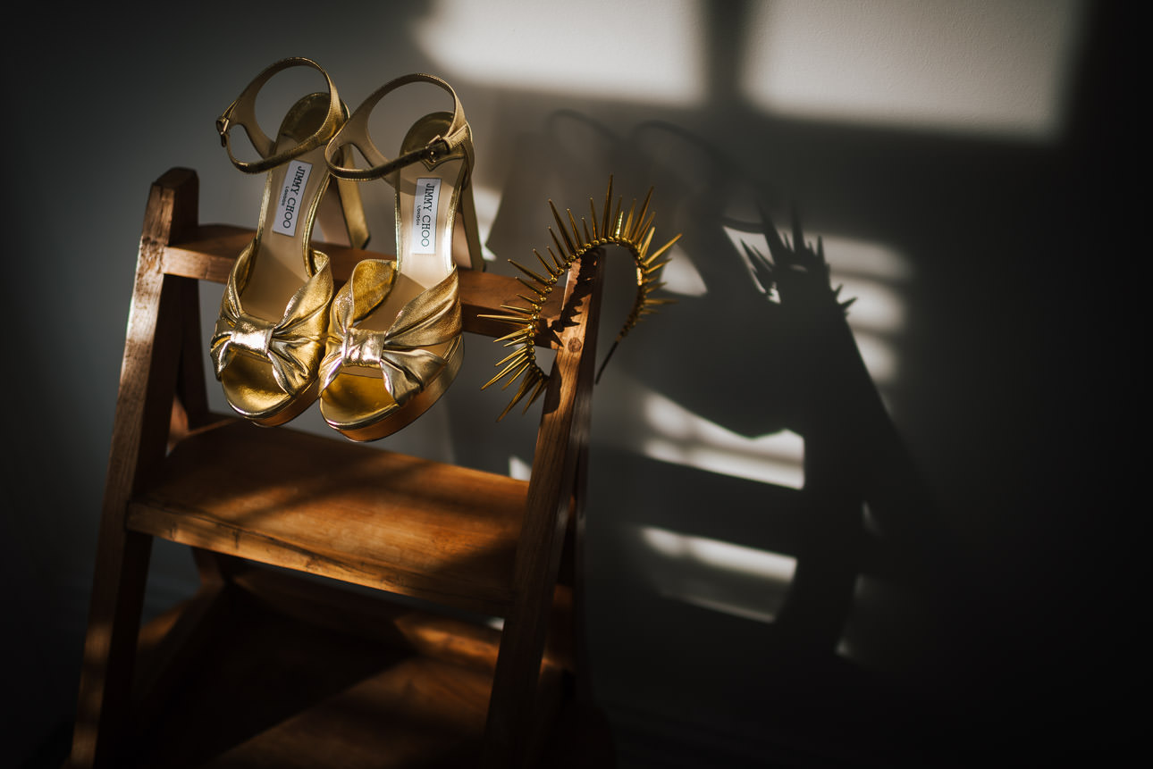 A pair of gold wedding shoes and a spikey tiara
