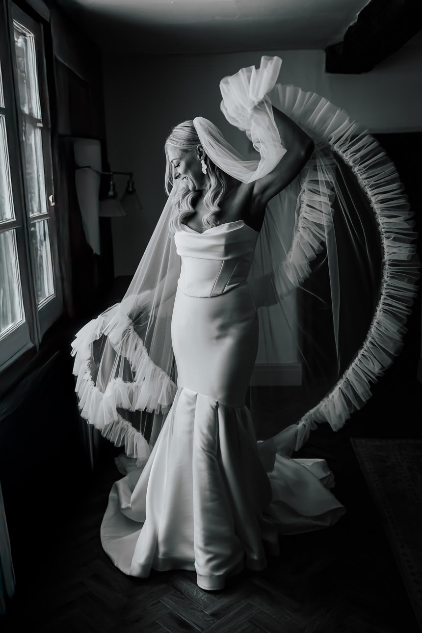 A bride waving her veil after getting ready at The River Barn