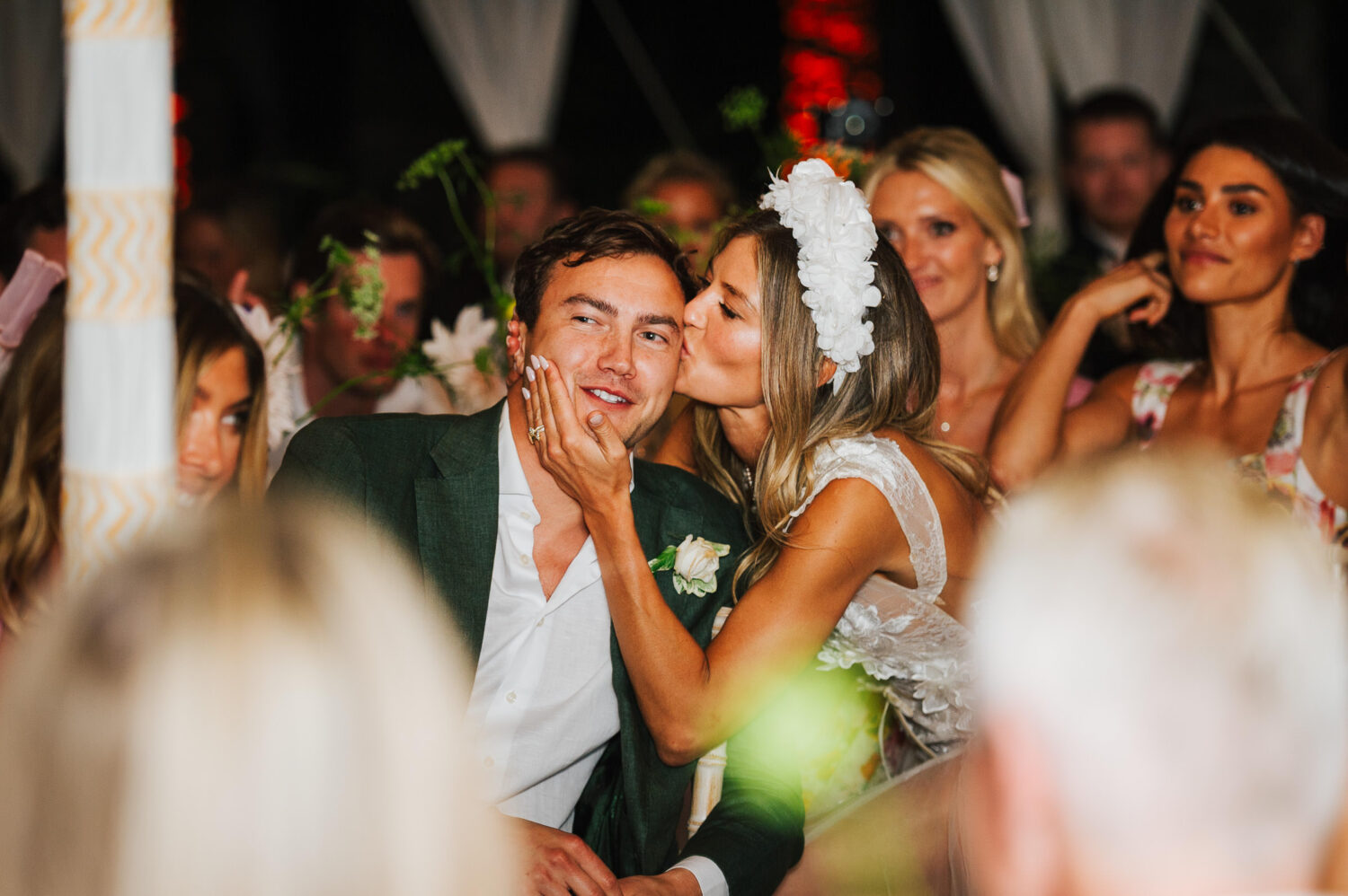 A bride kissing her groom on the head