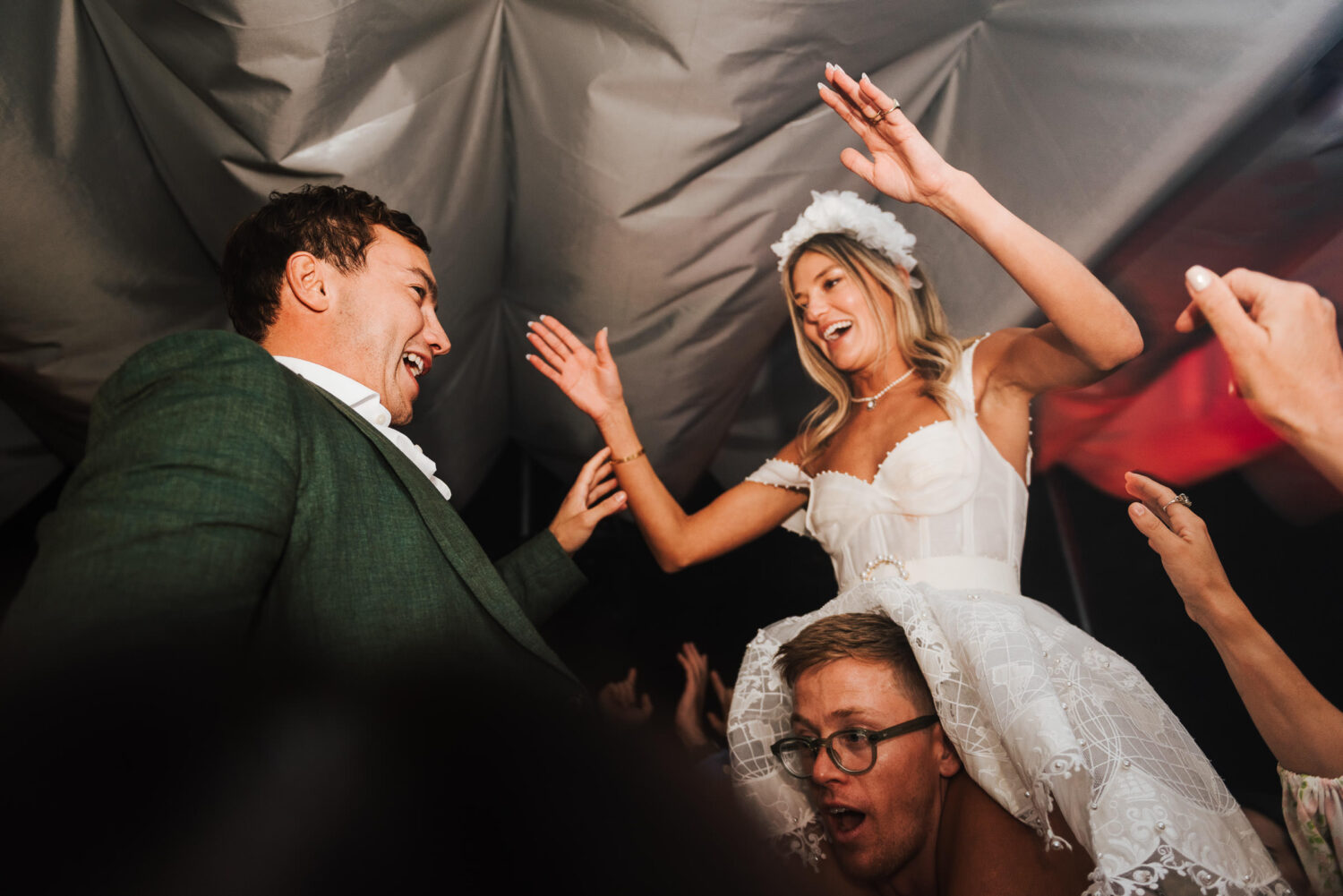 A bride and groom dancing on guests shoulders at their wedding in London on the Thames River