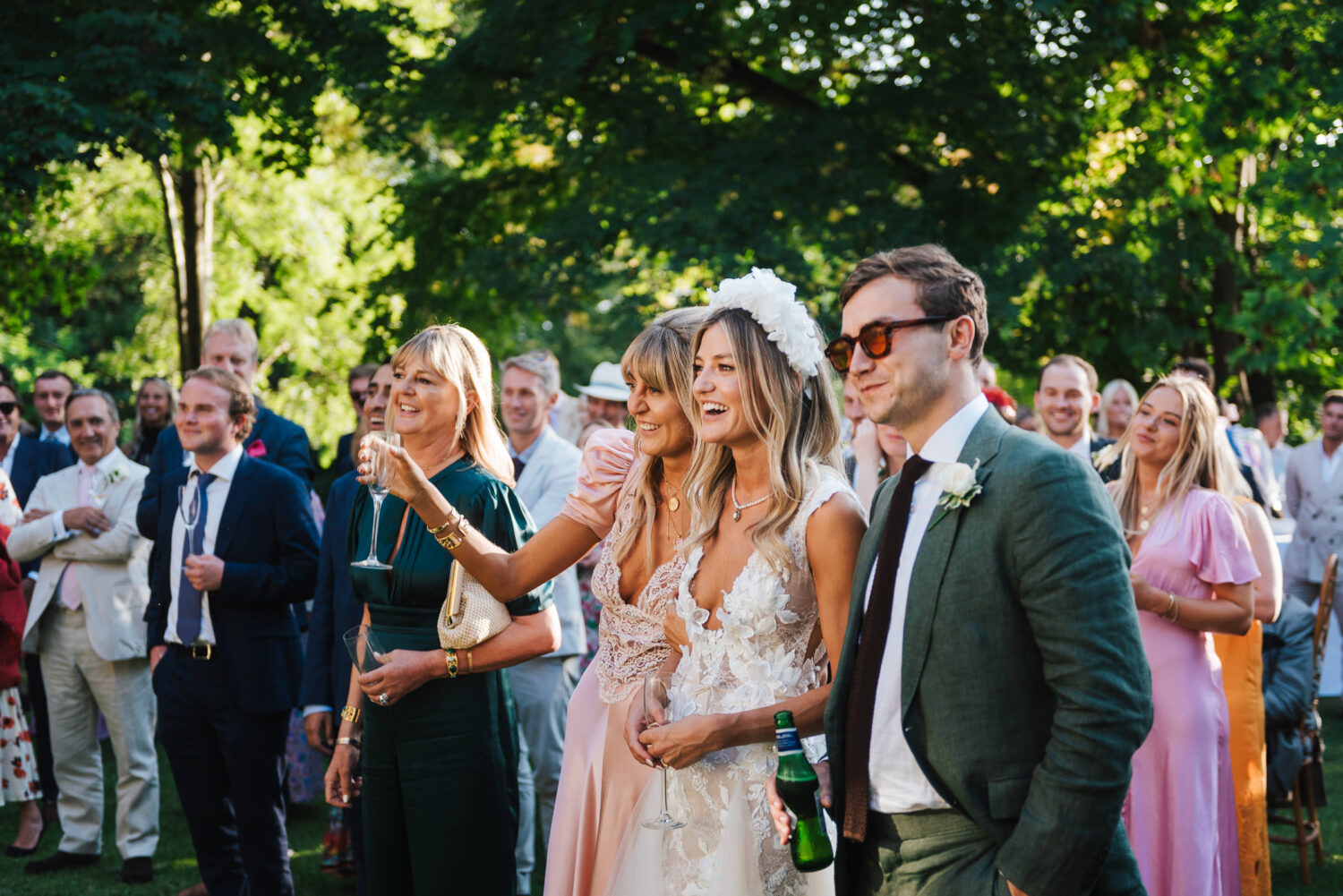 A bride and groom listening to speeches in the garden