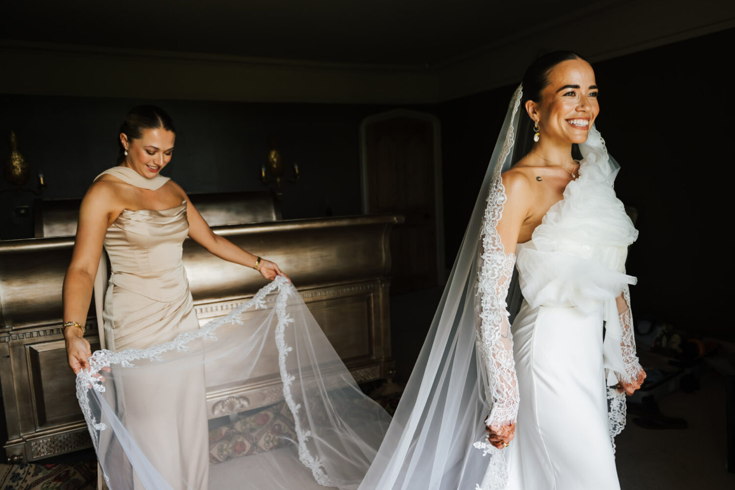 A bride having her veil fitted by her bridesmaid