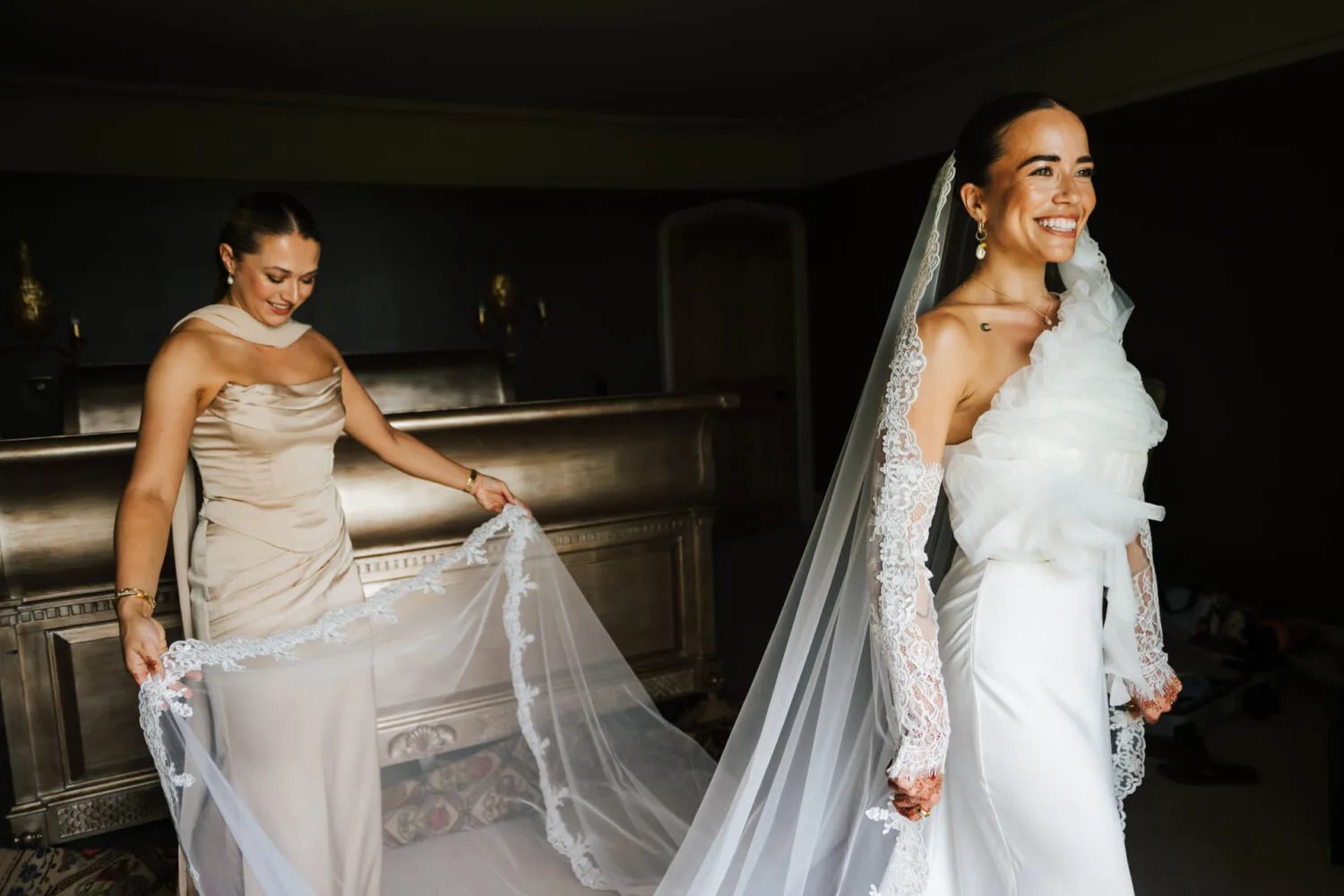 A bride having her veil fitted by her bridesmaid