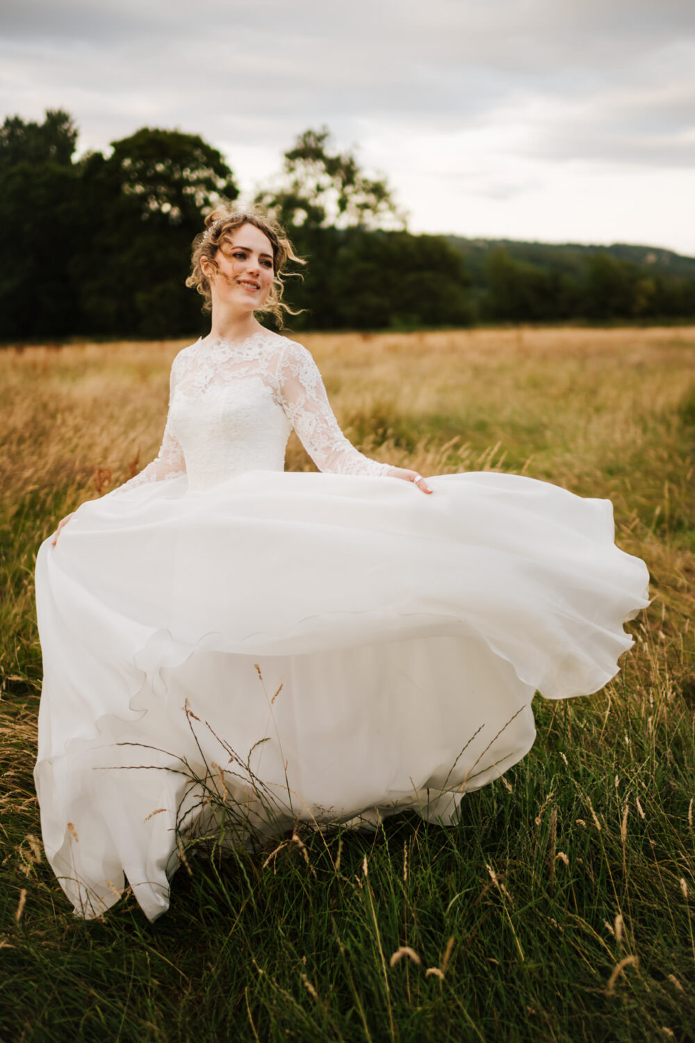 Bride walking through a meadow in a flowing wedding dress